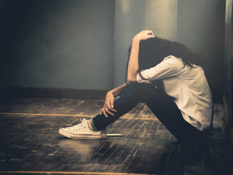 Sad young woman holds her head