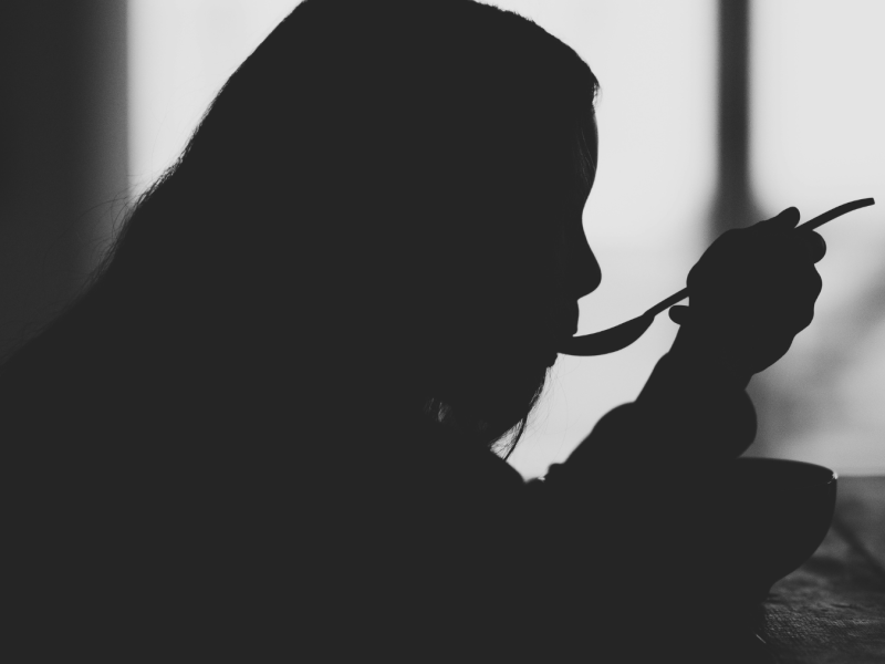 silhouette of a person eating in the dark