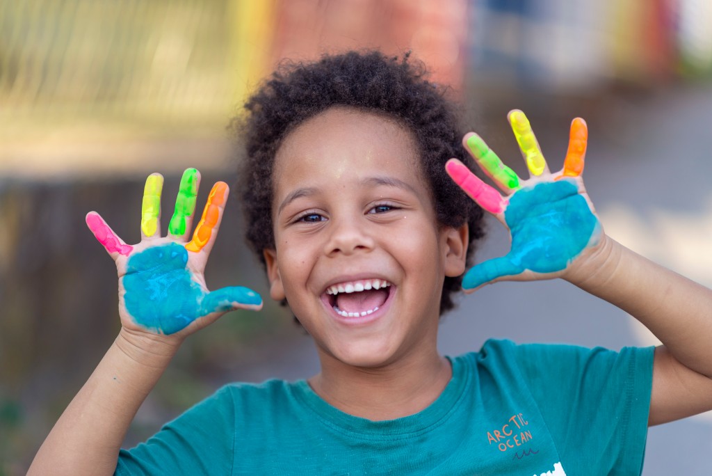 Happy pre-school boy with painted hands