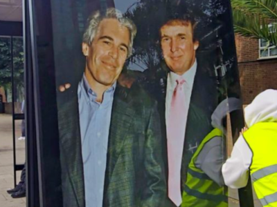 A worker installs a poster of Donald Trump and Jeffrey Epstein at a bus stop in Aberdeen.