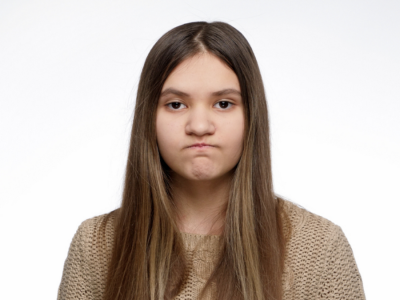 A teenage girl frowns.