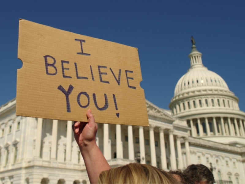 A person holds a sign that reads "I believe you!" outside of the U.S. Capitol building