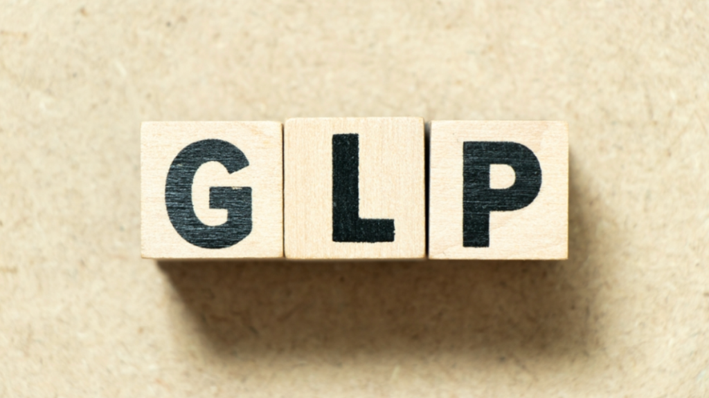 Wooden blocks with the letters "G" "L" and "P" sit on a surface