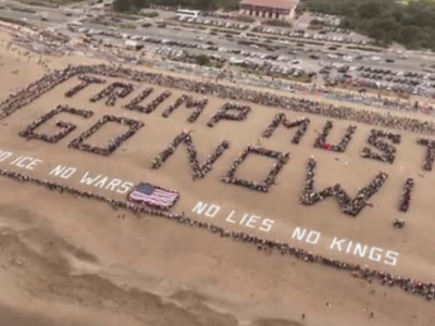 Protesters in San Francisco amassed on the beach, using their bodies to spell out "Trump Must Go Now!"