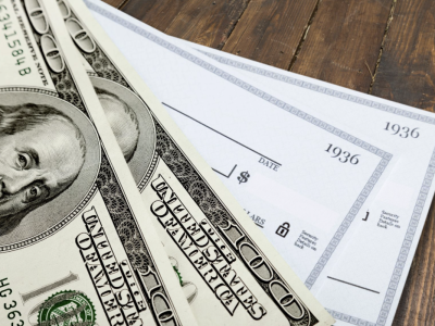 A stack of $100 bills and checks.