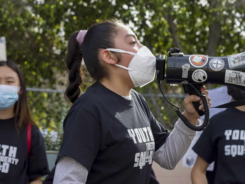 Members of the Youth Liberty Squad at a protest, with one student talking through a megaphone