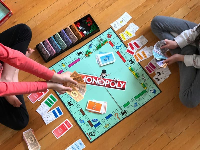 Image of two children playing Monopoly.