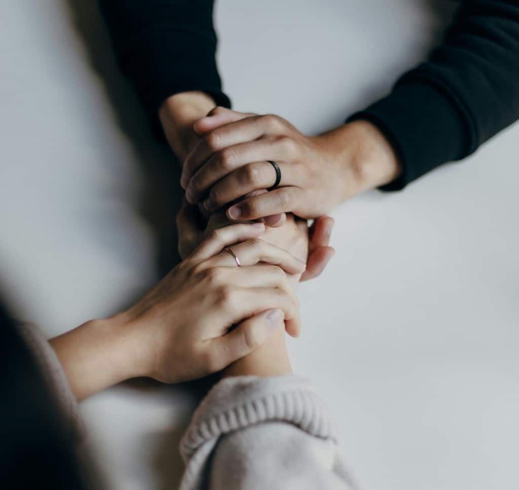 Close-up photo of two women holding hands.